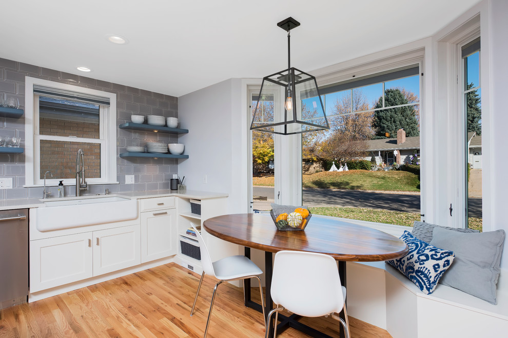 Large transitional u-shaped light wood floor enclosed kitchen photo in Denver with a farmhouse sink, shaker cabinets, white cabinets, quartz countertops, gray backsplash, ceramic backsplash, stainless steel appliances and an island