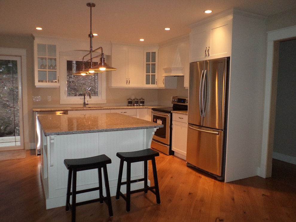 Mid-sized transitional l-shaped medium tone wood floor kitchen pantry photo in Toronto with a double-bowl sink, shaker cabinets, white cabinets, quartzite countertops, stainless steel appliances and an island