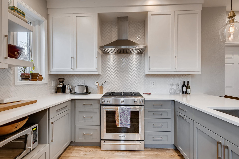 Small transitional u-shaped light wood floor and brown floor eat-in kitchen photo in Denver with an undermount sink, shaker cabinets, white cabinets, granite countertops, white backsplash, ceramic backsplash, stainless steel appliances, a peninsula and white countertops
