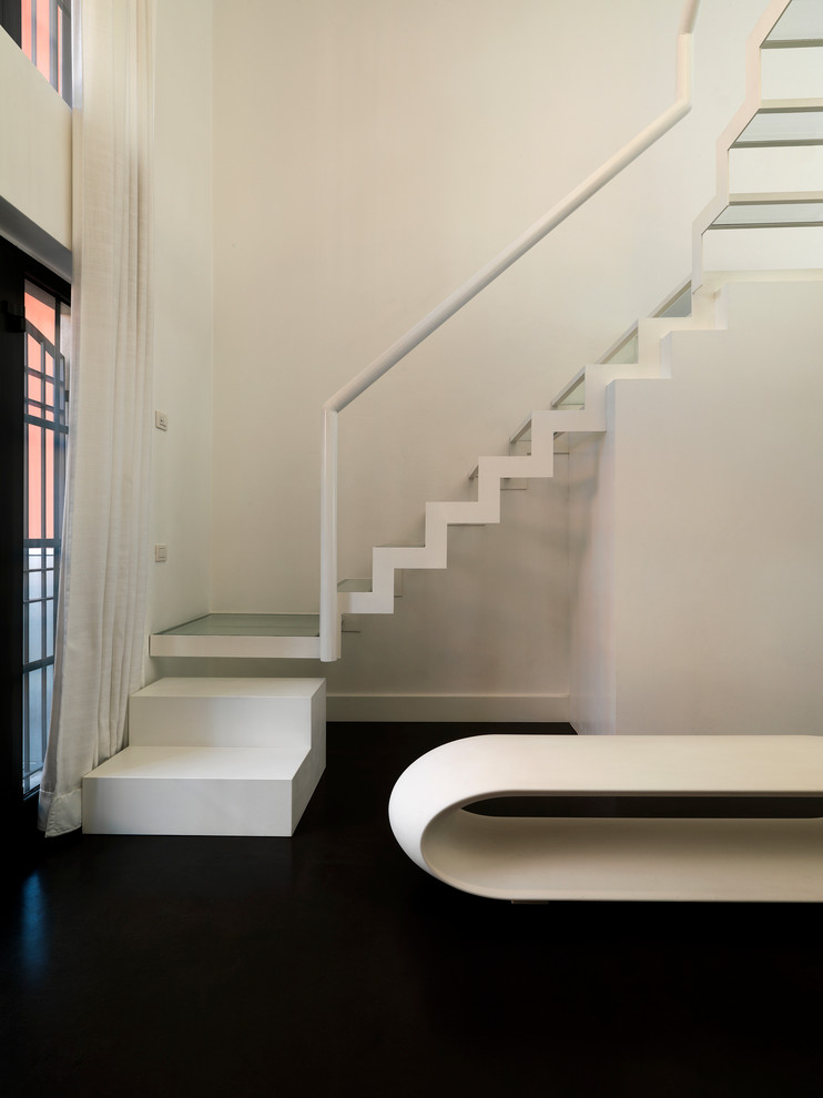 Small contemporary glass l-shaped staircase in Milan with open risers.