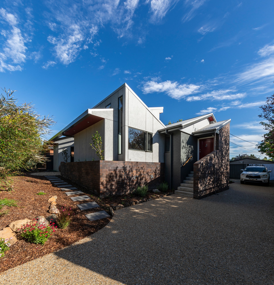 Small one-storey house exterior in Canberra - Queanbeyan with concrete fiberboard siding, a butterfly roof and a metal roof.