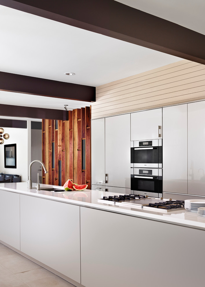 Inspiration for a large contemporary galley open plan kitchen in Austin with an undermount sink, flat-panel cabinets, solid surface benchtops, with island, white cabinets, white splashback, stainless steel appliances and ceramic floors.