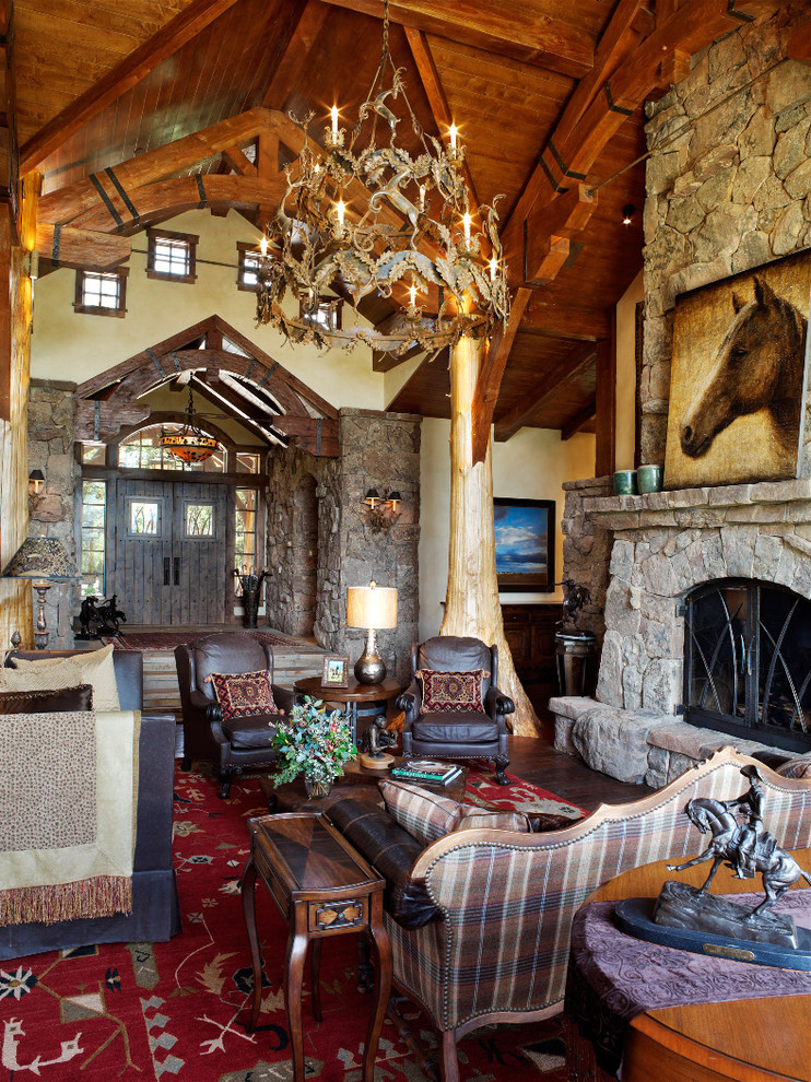 Inspiration for a country living room in Denver with a stone fireplace surround and dark hardwood floors.