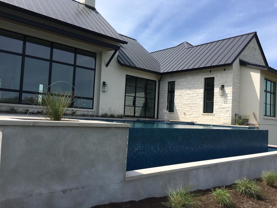Inspiration for a large modern backyard concrete and rectangular infinity hot tub remodel in Austin