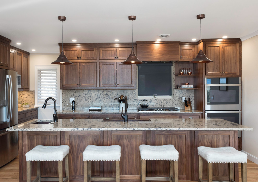 Kitchen - transitional l-shaped medium tone wood floor and brown floor kitchen idea with a farmhouse sink, shaker cabinets, dark wood cabinets, gray backsplash, stainless steel appliances, an island and gray countertops