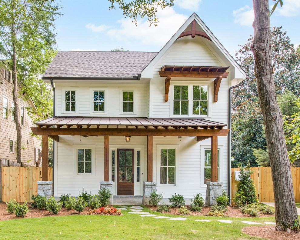 This is an example of a mid-sized traditional two-storey white exterior in Atlanta with a gable roof, a brown roof and a mixed roof.