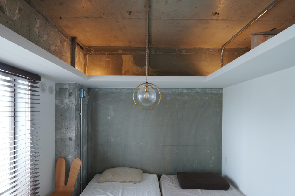 Diseño de dormitorio gris industrial pequeño con paredes grises, suelo de madera en tonos medios, suelo marrón, vigas vistas y machihembrado