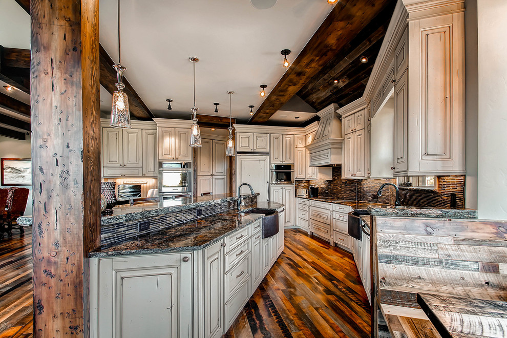 Open concept kitchen - rustic open concept kitchen idea in Denver with a farmhouse sink, raised-panel cabinets, beige cabinets, brown backsplash and paneled appliances