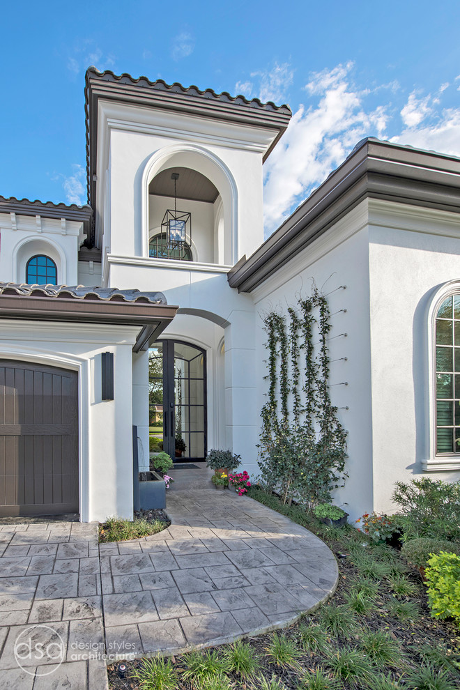 Design ideas for a large mediterranean two-storey stucco white house exterior in Tampa with a hip roof and a tile roof.