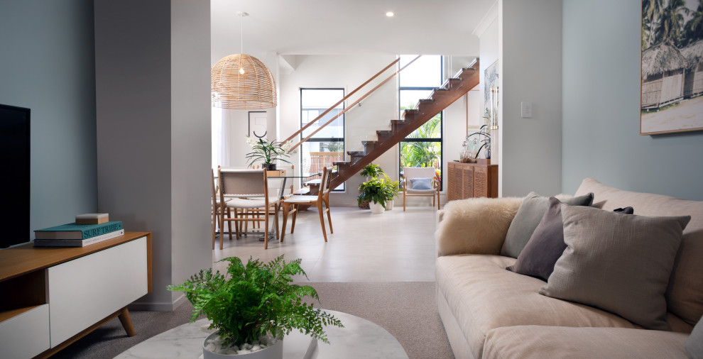 Large scandinavian open plan kitchen in Brisbane with a double-bowl sink, light wood cabinets, green splashback, ceramic splashback, stainless steel appliances, ceramic floors, with island, white floor and white benchtop.