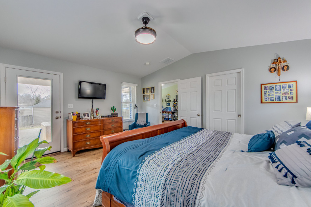 Imagen de dormitorio principal y abovedado tradicional renovado de tamaño medio con paredes grises, suelo vinílico y suelo beige