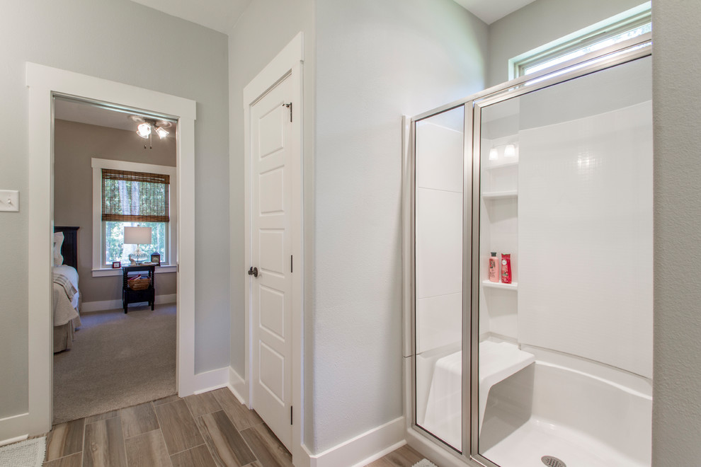 Design ideas for a mid-sized transitional master bathroom in Little Rock with shaker cabinets, white cabinets, an alcove shower, grey walls, porcelain floors, an undermount sink, marble benchtops, brown floor, a hinged shower door and grey benchtops.