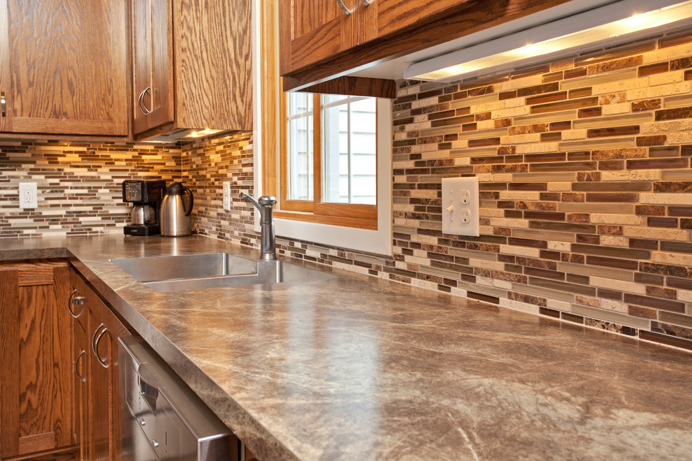 Inspiration for a mid-sized transitional l-shaped medium tone wood floor eat-in kitchen remodel in Milwaukee with dark wood cabinets, stainless steel appliances and an island