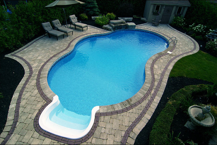 Mid-sized transitional backyard custom-shaped and concrete paver lap pool photo in Toronto