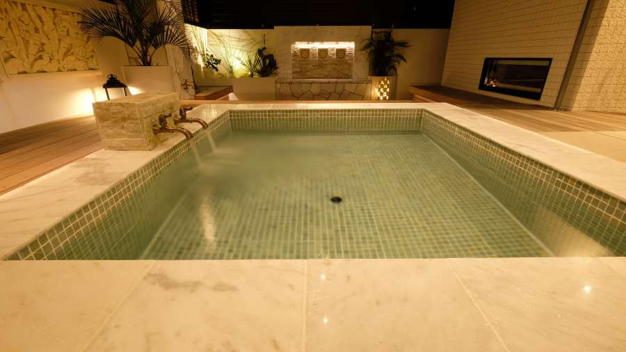 Exemple d'une grande piscine hors-sol exotique rectangle avec un bain bouillonnant, une cour et des pavés en pierre naturelle.