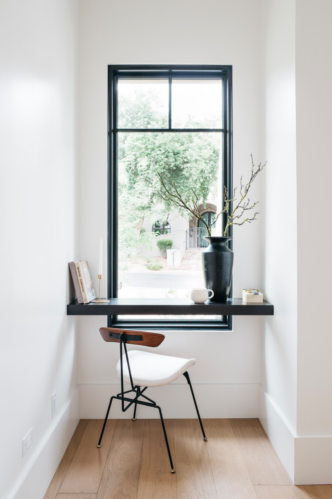 Idee per un grande studio tradizionale con libreria, pareti nere, parquet chiaro, scrivania incassata, pavimento beige e pannellatura