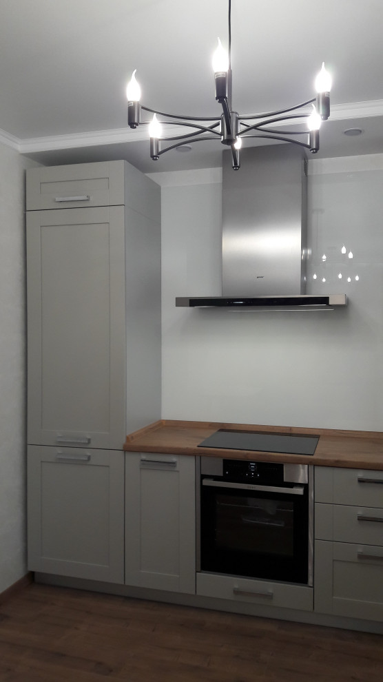 Серая кухня с фартуком из окрашенного белого стекла