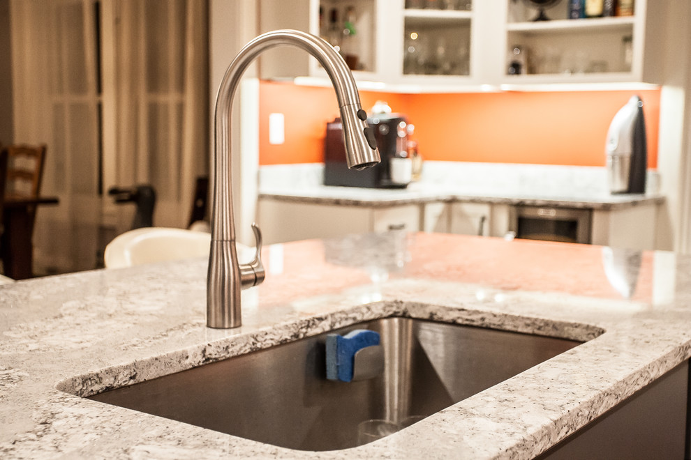 Enclosed kitchen - large transitional u-shaped light wood floor and brown floor enclosed kitchen idea in Baltimore with an undermount sink, shaker cabinets, white cabinets, gray backsplash, subway tile backsplash, stainless steel appliances, an island and quartz countertops