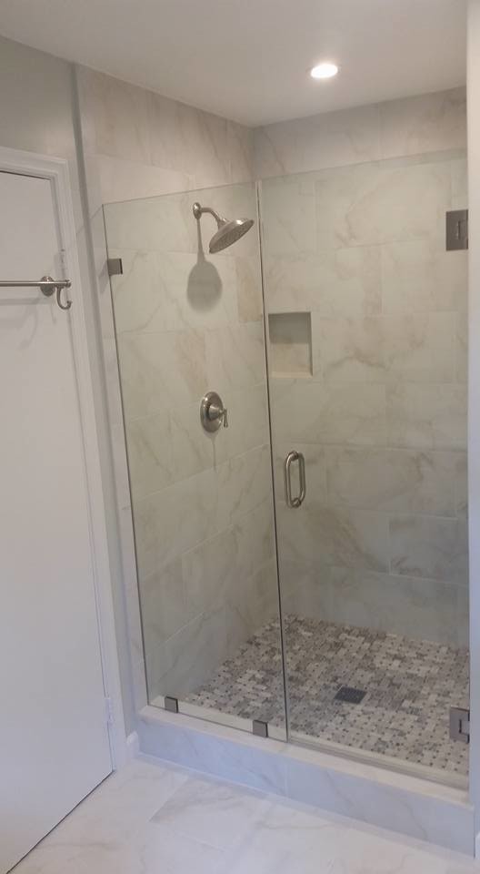 Design ideas for a mid-sized traditional 3/4 bathroom in DC Metro with shaker cabinets, black cabinets, an alcove shower, a one-piece toilet, beige tile, white tile, stone tile, beige walls, marble floors, an undermount sink, quartzite benchtops, white floor and a hinged shower door.