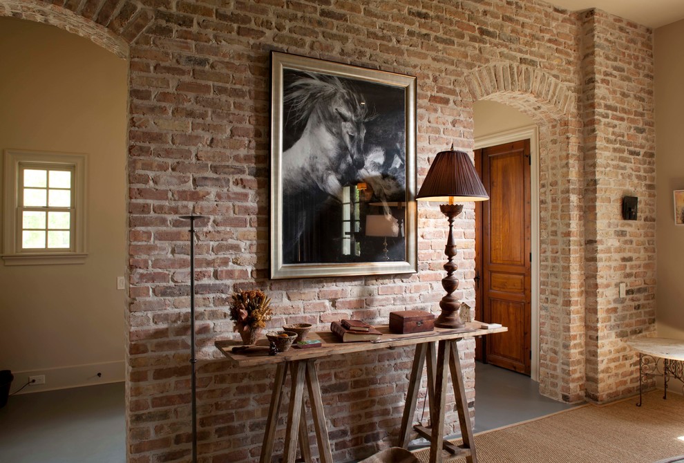 This is an example of an expansive traditional foyer in Houston with a double front door, a dark wood front door, grey floor and brick walls.