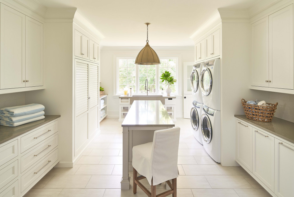 Photo of a beach style utility room in Charlotte with engineered stone countertops, white walls, a stacked washer and dryer and grey worktops.