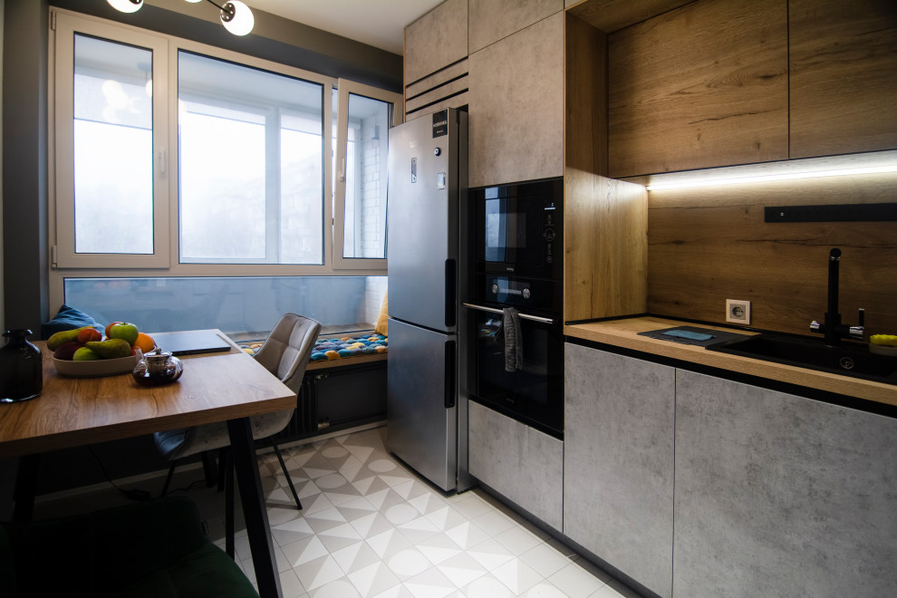 Photo of a small scandi l-shaped kitchen/diner in Moscow with a submerged sink, flat-panel cabinets, medium wood cabinets, wood worktops, beige splashback, wood splashback, black appliances, ceramic flooring, no island, grey floors and beige worktops.