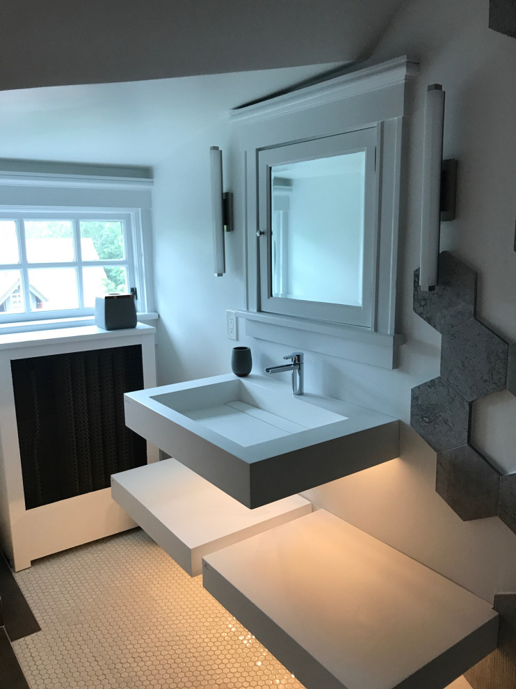 Modern inredning av ett litet vit vitt badrum med dusch, med vita skåp, våtrum, en vägghängd toalettstol, grå kakel, cementkakel, vita väggar, klinkergolv i keramik, ett väggmonterat handfat, vitt golv och med dusch som är öppen