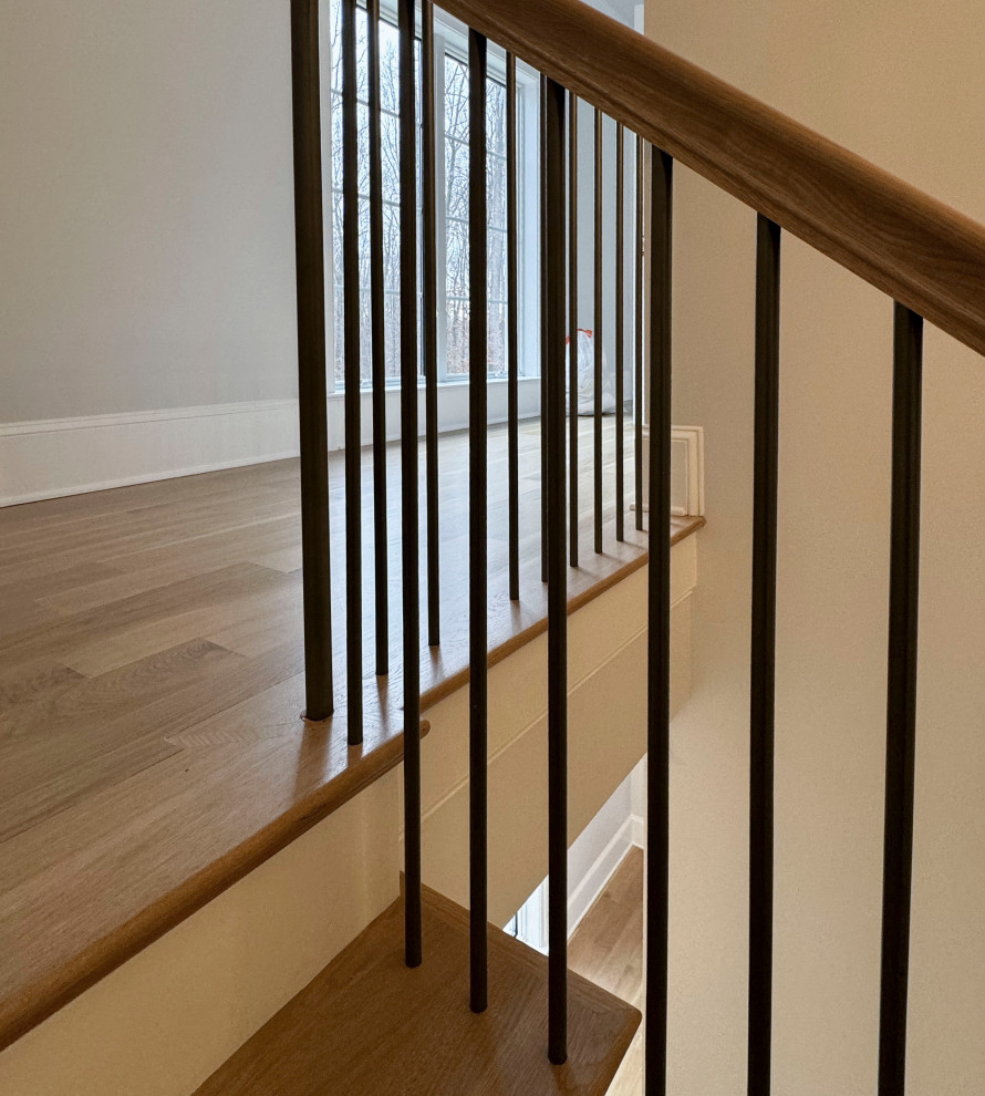 Inspiration for a large traditional wood floating mixed railing staircase in DC Metro with painted wood risers.