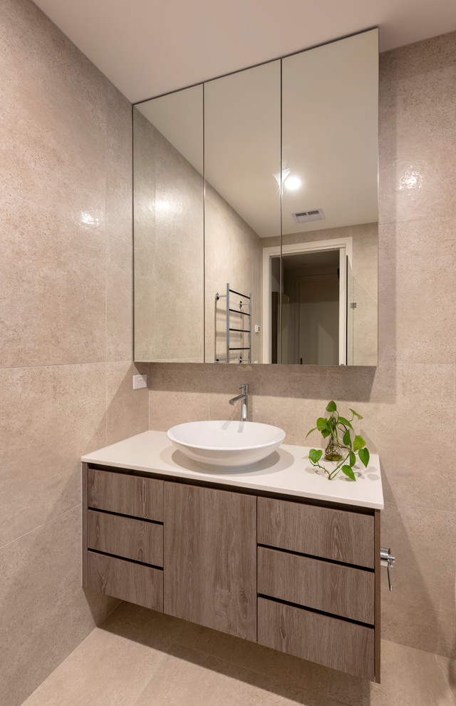 Inspiration for a large contemporary wet room bathroom in Melbourne with shaker cabinets, light wood cabinets, a freestanding tub, brown tile, porcelain tile, brown walls, porcelain floors, a vessel sink, engineered quartz benchtops, brown floor, a hinged shower door and white benchtops.