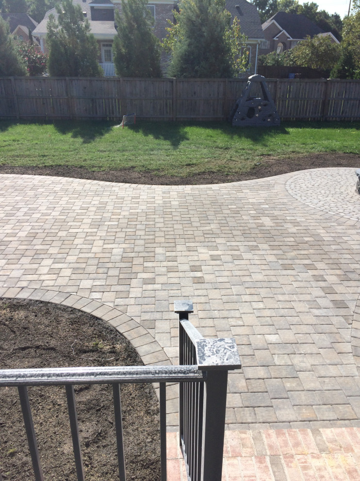 Photo of a large traditional backyard patio in Other with a fire feature, concrete pavers and no cover.