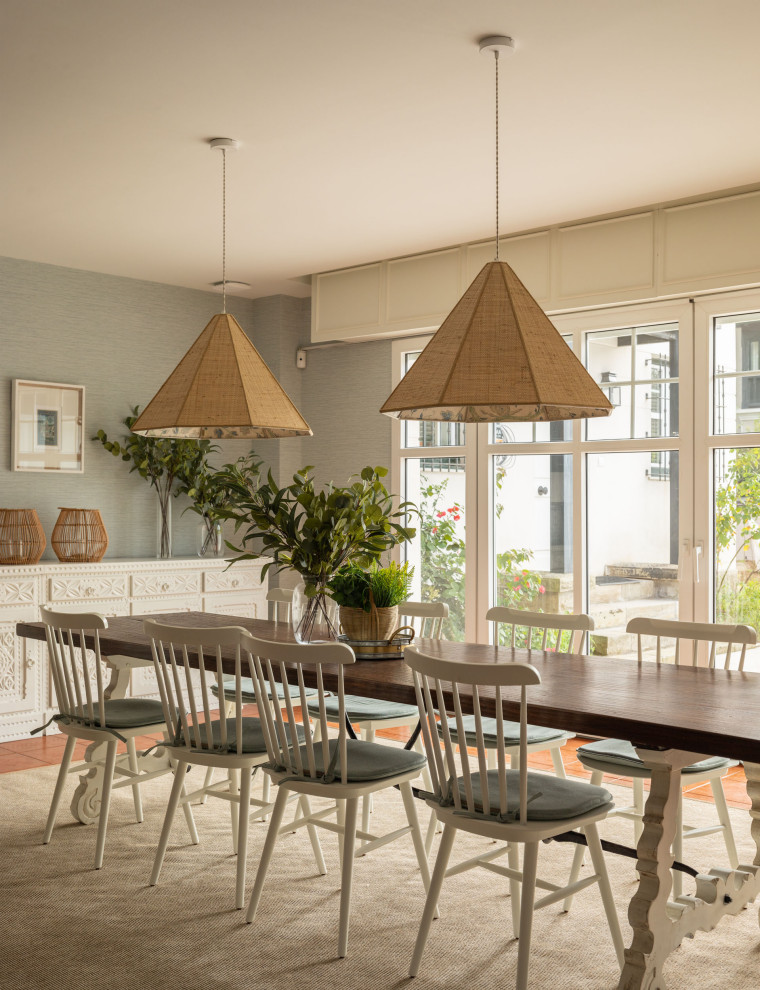 Modelo de comedor tradicional renovado grande abierto con paredes azules, suelo de baldosas de cerámica, todas las chimeneas, marco de chimenea de piedra, suelo marrón, papel pintado y alfombra