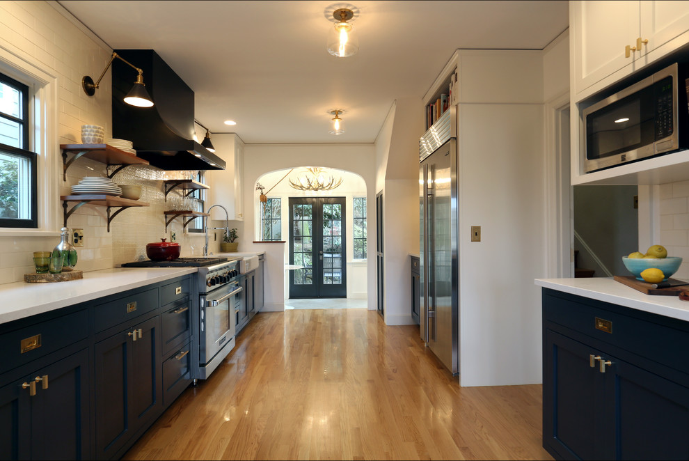 Inspiration for a mid-sized eclectic galley eat-in kitchen in Portland with an undermount sink, shaker cabinets, grey cabinets, quartz benchtops, white splashback, subway tile splashback, stainless steel appliances, light hardwood floors and no island.