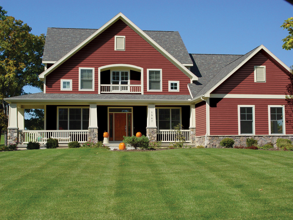 Inspiration for a traditional two-storey red exterior in Grand Rapids with metal siding and a shingle roof.