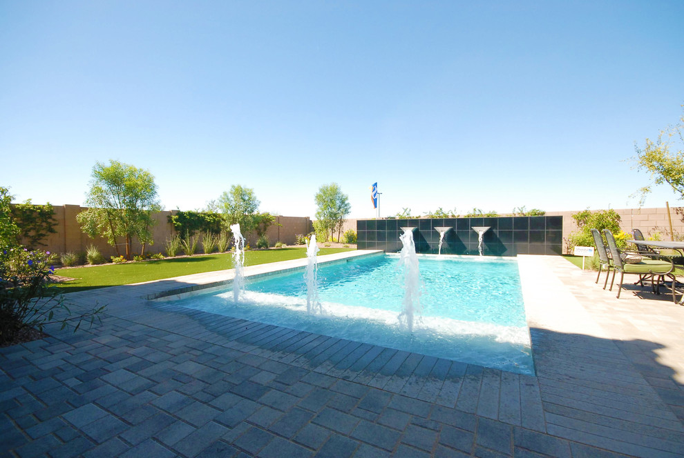 Design ideas for a mid-sized backyard rectangular lap pool in Phoenix with brick pavers.
