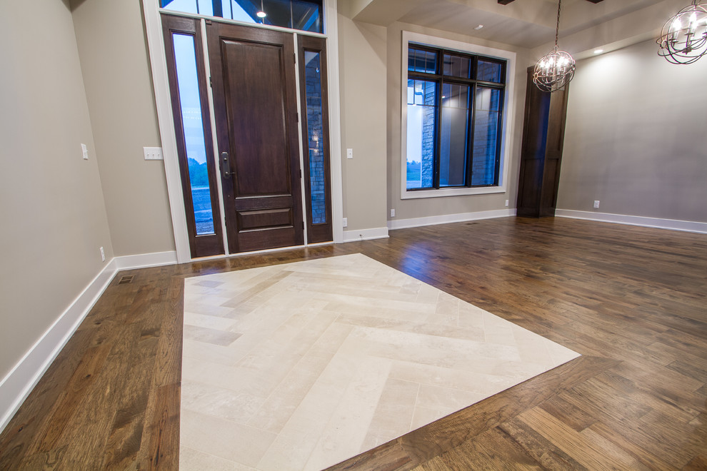 Large transitional medium tone wood floor foyer photo in Omaha with beige walls and a dark wood front door