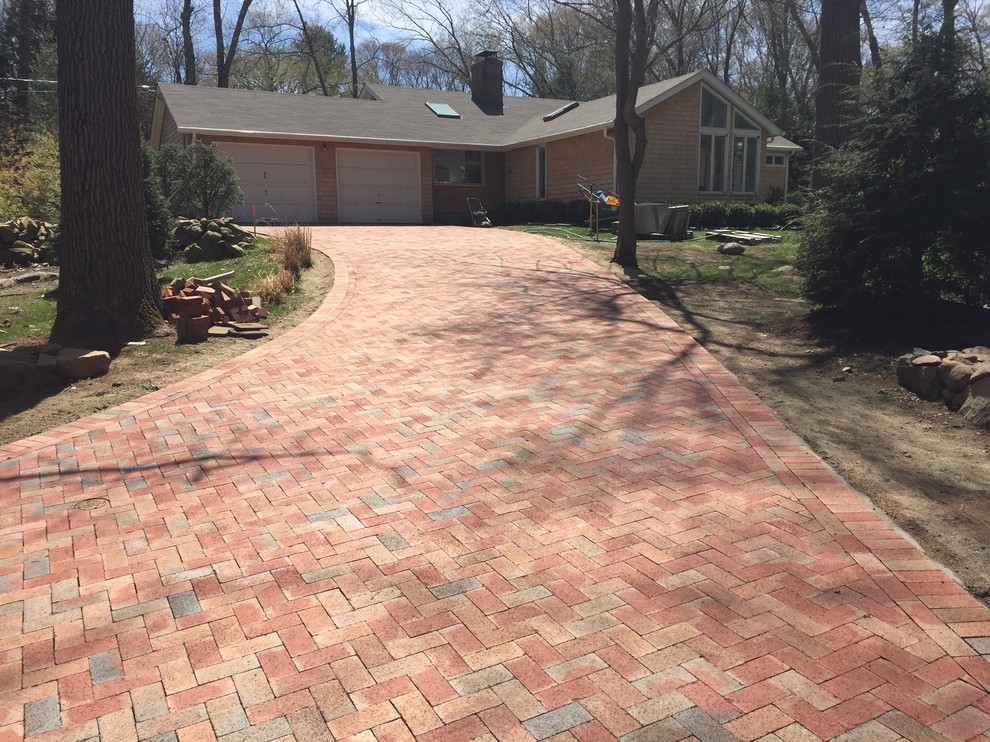 Design ideas for a mid-sized contemporary front yard full sun driveway in Providence with a water feature and brick pavers.