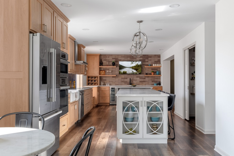 Design ideas for a large transitional galley eat-in kitchen in Columbus with a farmhouse sink, shaker cabinets, light wood cabinets, quartz benchtops, blue splashback, ceramic splashback, stainless steel appliances, vinyl floors, multiple islands, brown floor and white benchtop.