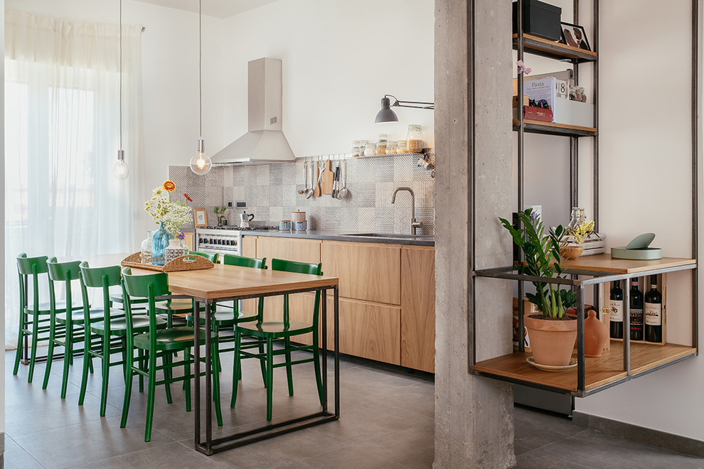Inspiration for an industrial single-wall eat-in kitchen in Naples with an undermount sink, beaded inset cabinets, grey splashback, porcelain splashback, stainless steel appliances, porcelain floors, grey floor and grey benchtop.