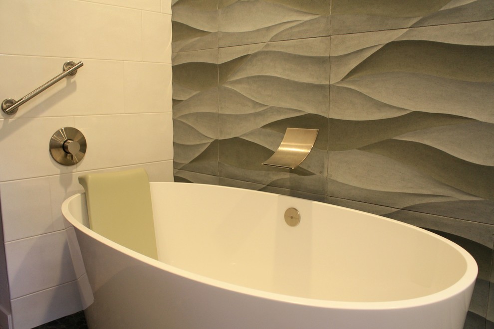 Inredning av ett modernt mycket stort grå grått en-suite badrum, med släta luckor, skåp i mellenmörkt trä, ett platsbyggt badkar, en kantlös dusch, grå kakel, cementkakel, ett undermonterad handfat, bänkskiva i återvunnet glas, blått golv, med dusch som är öppen, vita väggar och klinkergolv i småsten
