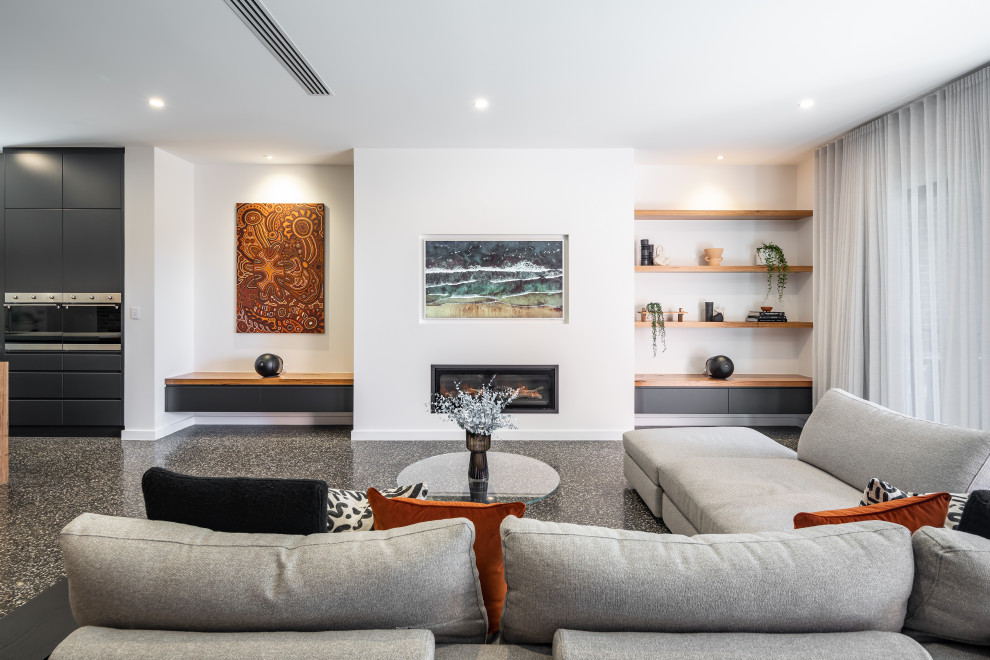 Foto di un grande soggiorno moderno aperto con pareti bianche, camino lineare Ribbon, pavimento in cemento, pavimento nero e TV a parete