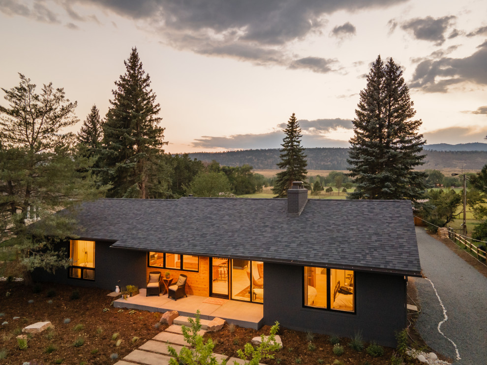 This is an example of a mid-sized midcentury one-storey black house exterior in Denver.
