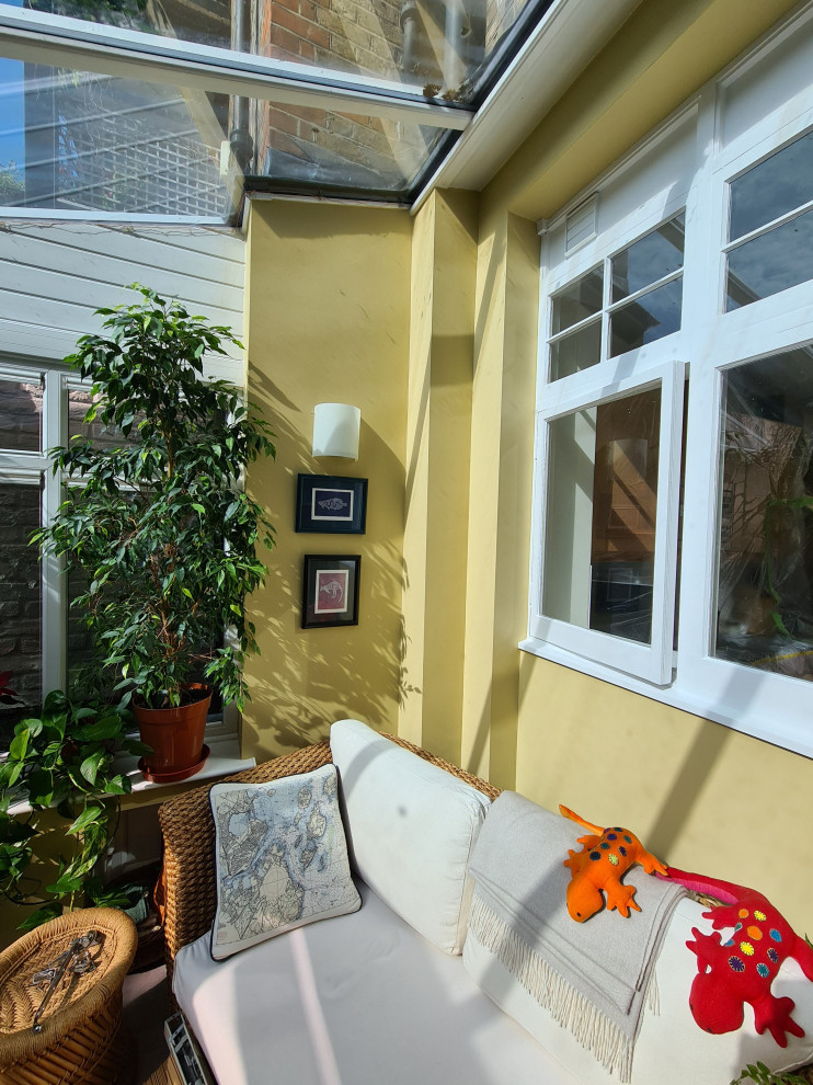 Exemple d'un porche d'entrée de maison arrière chic de taille moyenne avec une moustiquaire, du carrelage, une extension de toiture et un garde-corps en verre.