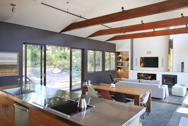 Photo of a mid-sized modern single-wall kitchen in San Francisco with a drop-in sink, flat-panel cabinets, medium wood cabinets, stainless steel benchtops, stainless steel appliances, with island and concrete floors.