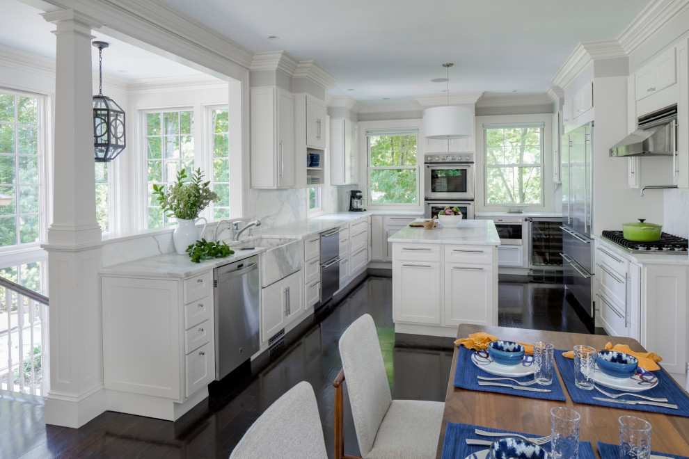 Mid-sized transitional u-shaped eat-in kitchen in Boston with recessed-panel cabinets, white cabinets, marble benchtops, multi-coloured splashback, marble splashback, stainless steel appliances, dark hardwood floors, with island, brown floor, white benchtop and an integrated sink.