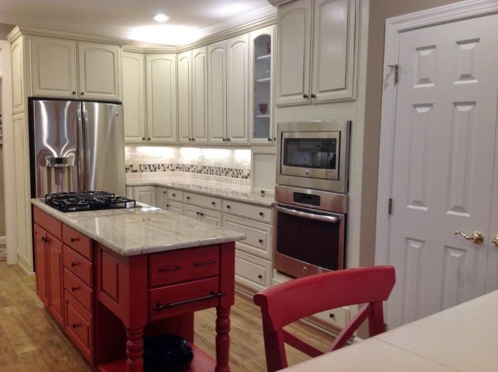 This is an example of a large country galley eat-in kitchen in Raleigh with a double-bowl sink, raised-panel cabinets, white cabinets, granite benchtops, beige splashback, glass tile splashback, stainless steel appliances, ceramic floors and with island.
