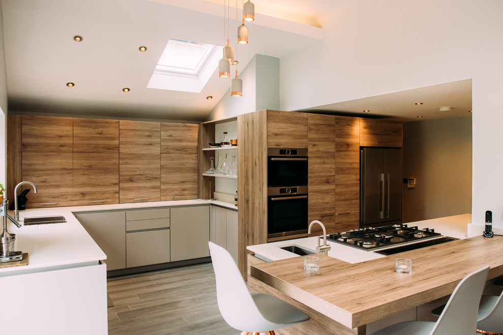 This is an example of a large contemporary open plan kitchen in Cheshire with black appliances and with island.