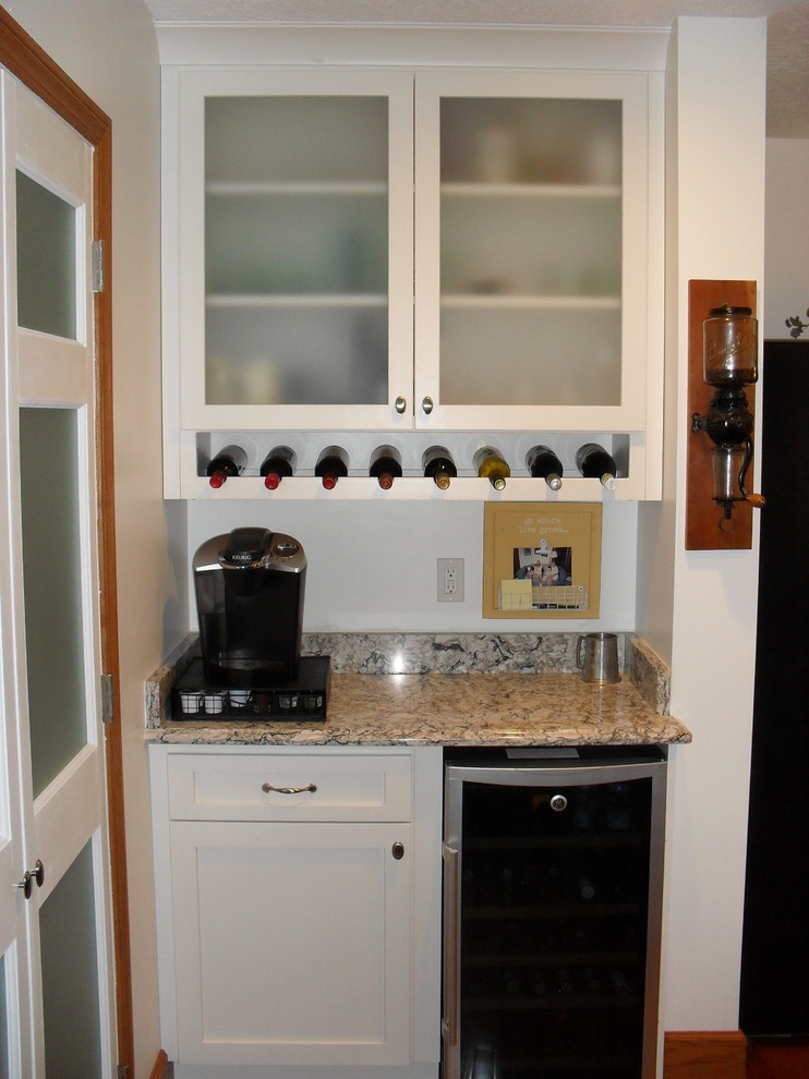 Example of a large transitional medium tone wood floor open concept kitchen design with white cabinets, white backsplash, black appliances, an island, a farmhouse sink, recessed-panel cabinets and subway tile backsplash
