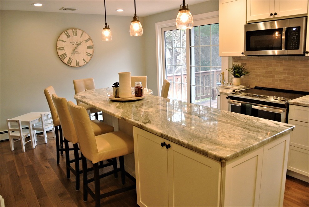 Kitchen - transitional l-shaped medium tone wood floor kitchen idea in Boston with an undermount sink, shaker cabinets, white cabinets, granite countertops, beige backsplash, subway tile backsplash, stainless steel appliances and an island