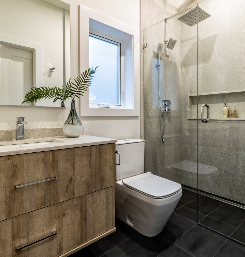 Photo of a large contemporary ensuite bathroom in Vancouver with flat-panel cabinets, brown cabinets, a freestanding bath, a built-in shower, a two-piece toilet, grey tiles, porcelain tiles, white walls, porcelain flooring, a submerged sink, engineered stone worktops, white floors, a hinged door, beige worktops, a wall niche, a single sink and a floating vanity unit.