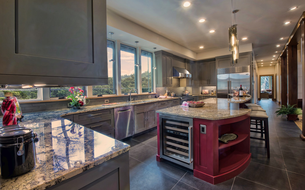 Eat-in kitchen - large transitional u-shaped limestone floor eat-in kitchen idea with an undermount sink, shaker cabinets, gray cabinets, granite countertops, gray backsplash, glass tile backsplash, stainless steel appliances and an island